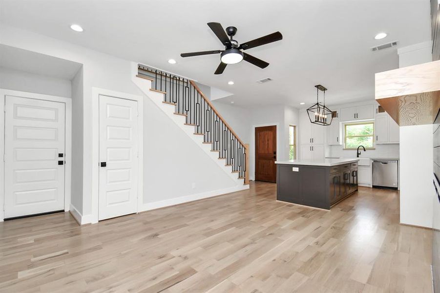 In this view of the living area looking toward the kitchen, we see the door on the left which leads to the garage, and the door just to the right of it which leads to the half bath located under the stairs!