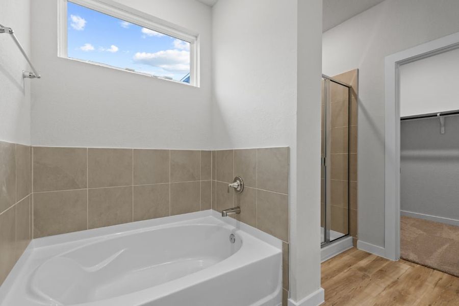 A bathroom with a tub and shower. A bathroom with a tub and shower.