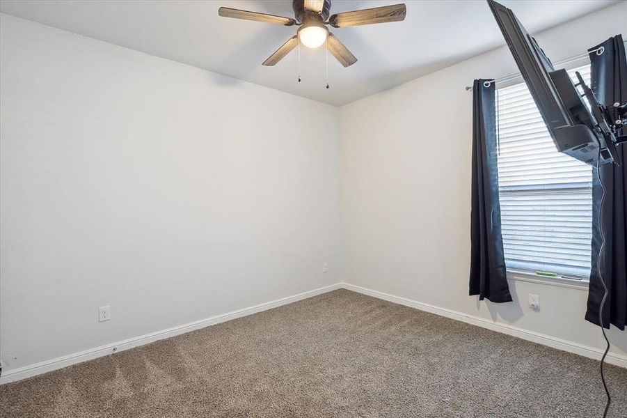 Carpeted empty room featuring ceiling fan Carpeted empty room featuring ceiling fan