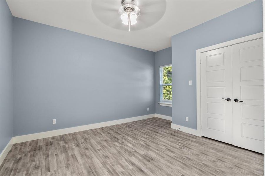 Unfurnished bedroom with a closet, light wood-type flooring, and ceiling fan