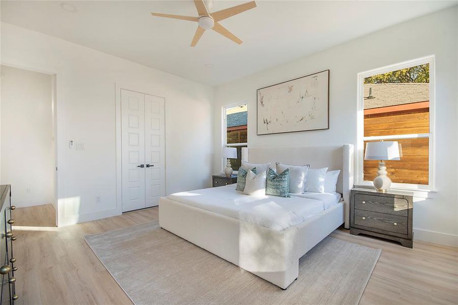 Bedroom featuring light wood-style floors, a ceiling fan, and a closet Bedroom featuring light wood-style floors, a ceiling fan, and a closet