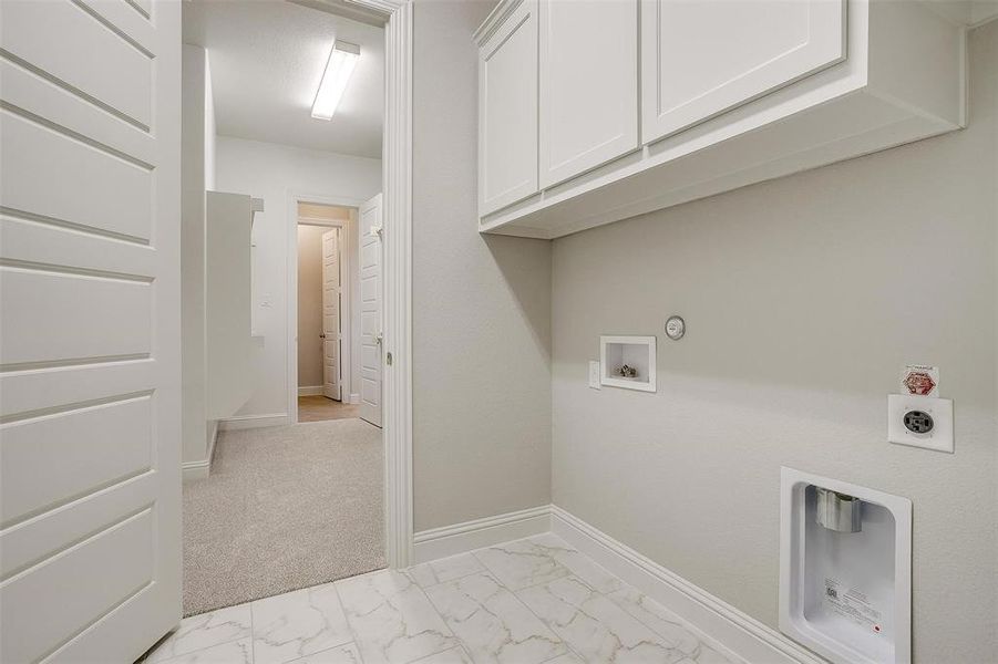 Laundry area with light tile patterned flooring, washer hookup, cabinets, electric dryer hookup, and hookup for a gas dryer