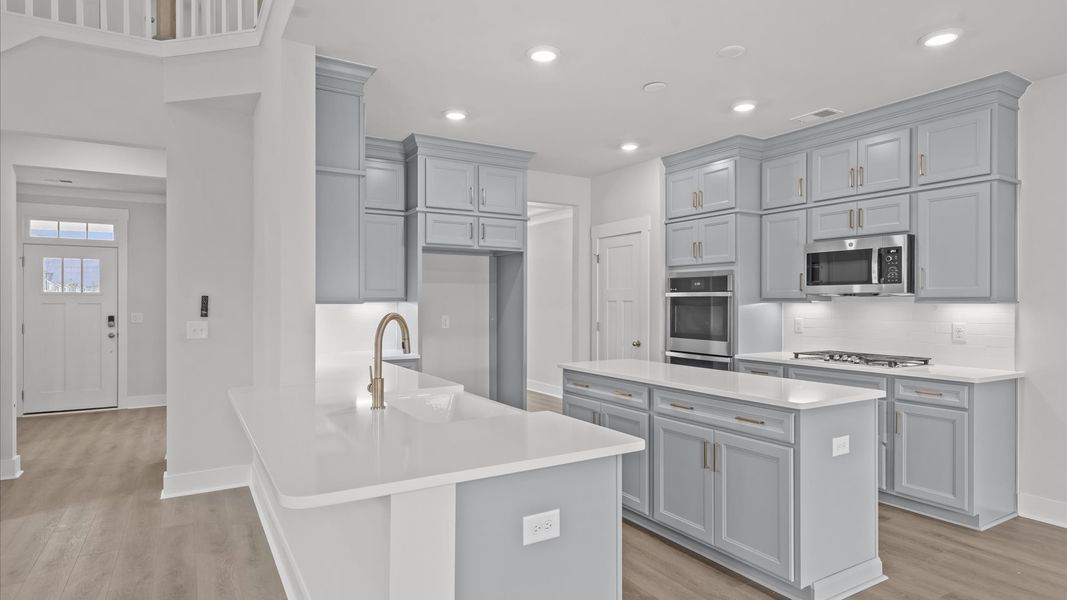 First-class kitchen with a spacious 9-foot island perfect for entertaining beneath designer pendant lighting