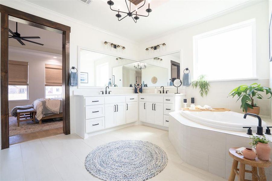 Ensuite bathroom with suspended lighting, double vanity, a bath, light tile patterned flooring, and a ceiling fan Ensuite bathroom with suspended lighting, double vanity, a bath, light tile patterned flooring, and a ceiling fan