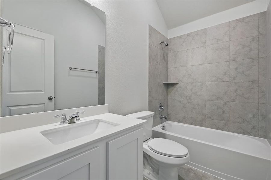 Bathroom with vanity, shower / washtub combination, and vaulted ceiling