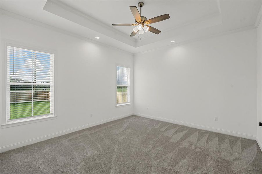Carpeted empty room featuring a tray ceiling, crown molding, recessed lighting, and ceiling fan Carpeted empty room featuring a tray ceiling, crown molding, recessed lighting, and ceiling fan