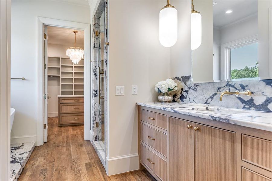 Full bath with a stall shower, vanity, light wood-style floors, ornamental molding, and tasteful backsplash Full bath with a stall shower, vanity, light wood-style floors, ornamental molding, and tasteful backsplash