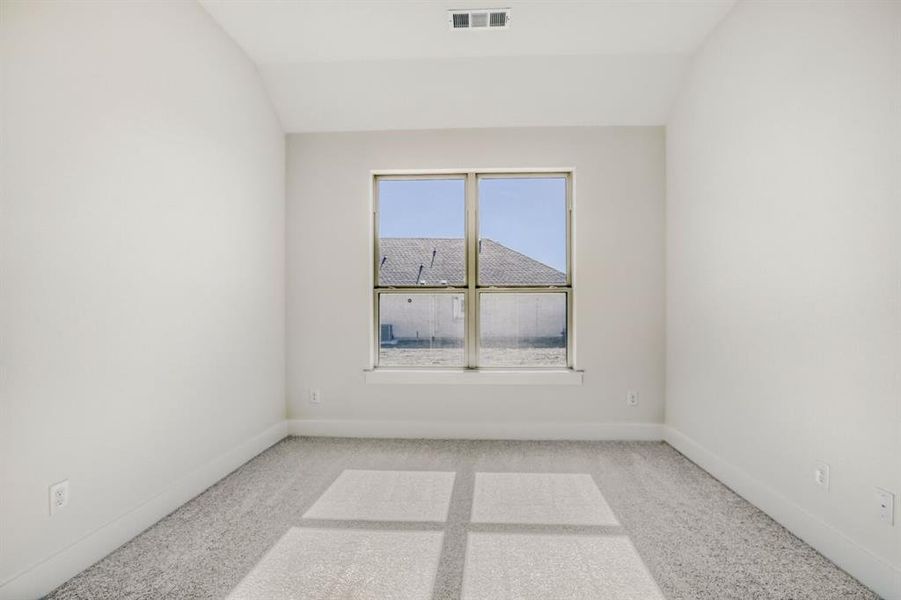 Spare room with lofted ceiling and light colored carpet