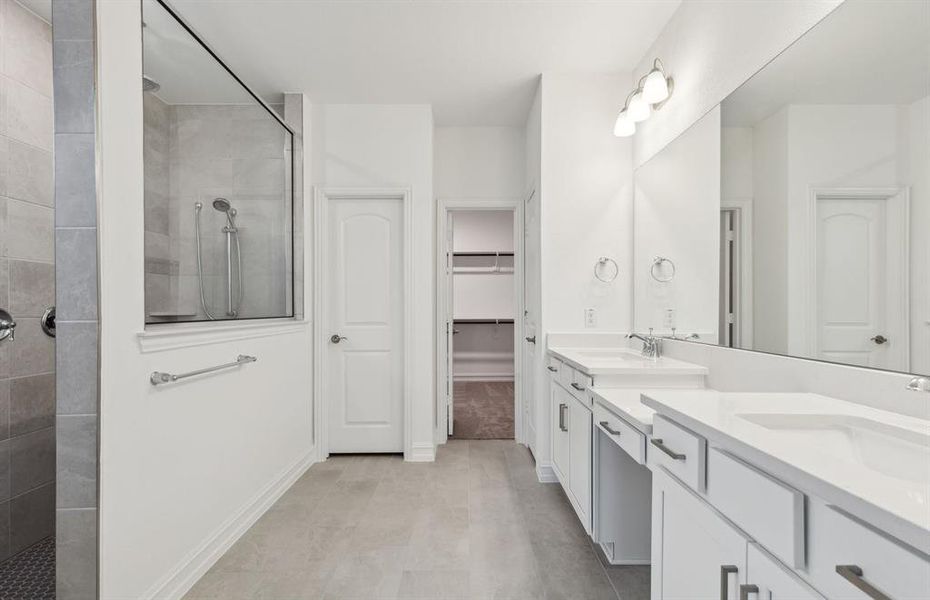 Spacious owner's suite with dual vanity and oversized shower*real home pictured