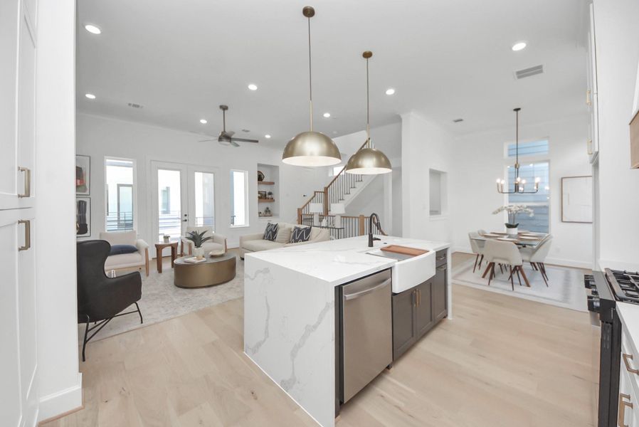 This bright, modern living room radiates warmth and style. Light wood floors and a ceiling fan complement the abundance of natural light streaming through large windows. A comfortable seating area with neutral tones, decorative pillows, and stylish accents creates an inviting atmosphere, while contemporary art, a sleek staircase railing, and indoor plants add touches of sophistication and greenery. This bright, modern living room radiates warmth and style. Light wood floors and a ceiling fan complement the abundance of natural light streaming through large windows. A comfortable seating area with neutral tones, decorative pillows, and stylish accents creates an inviting atmosphere, while contemporary art, a sleek staircase railing, and indoor plants add touches of sophistication and greenery.