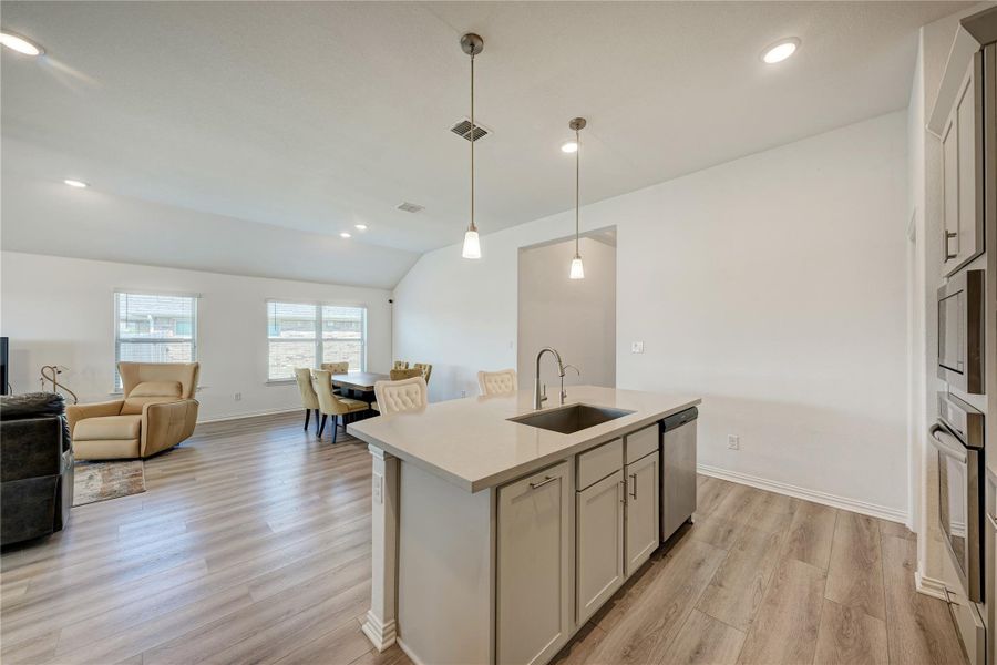 An open concept design seamlessly blends the kitchen, dining, and living areas.