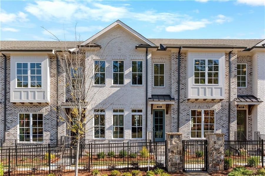 View of front facade with a fenced front yard, brick siding, and a gate View of front facade with a fenced front yard, brick siding, and a gate