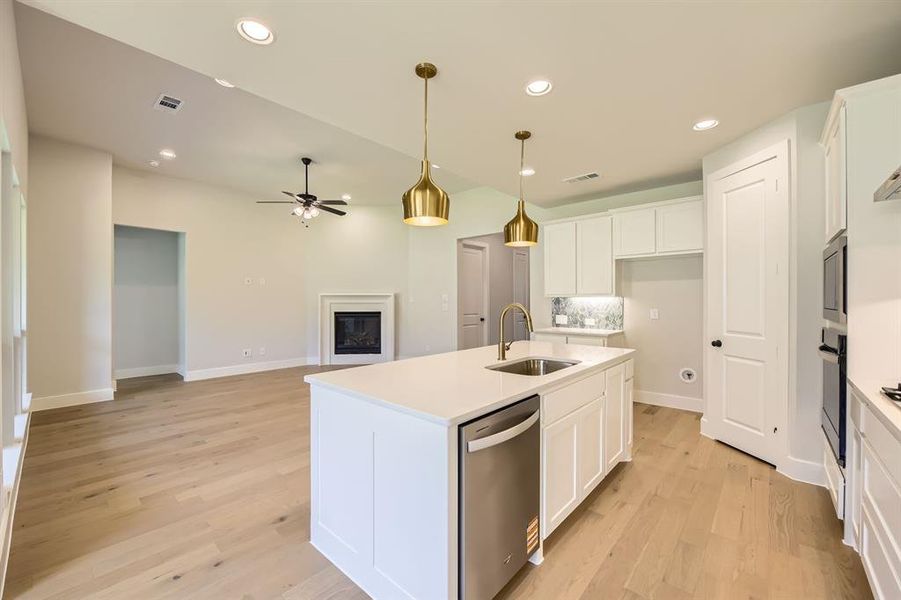 Kitchen with a ceiling fan, stainless steel dishwasher, white cabinets, light wood-style floors, and recessed lighting Kitchen with a ceiling fan, stainless steel dishwasher, white cabinets, light wood-style floors, and recessed lighting