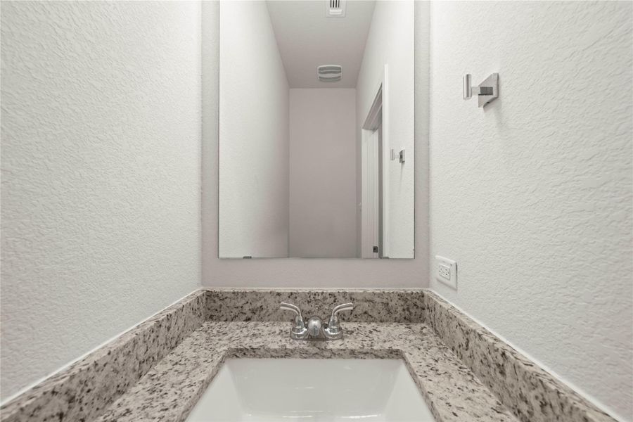A well-appointed bathroom vanity features a granite countertop and a contemporary sink.