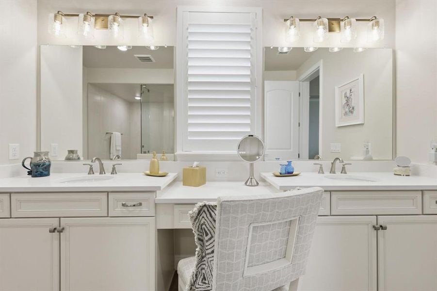 Full bathroom featuring double vanity and a shower stall