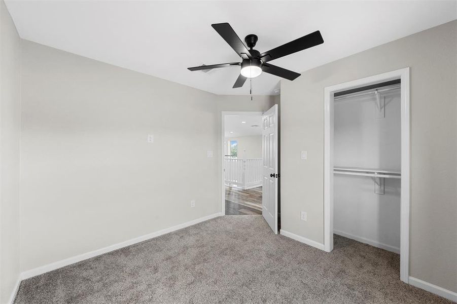 Unfurnished bedroom with a closet, light colored carpet, and ceiling fan Unfurnished bedroom with a closet, light colored carpet, and ceiling fan