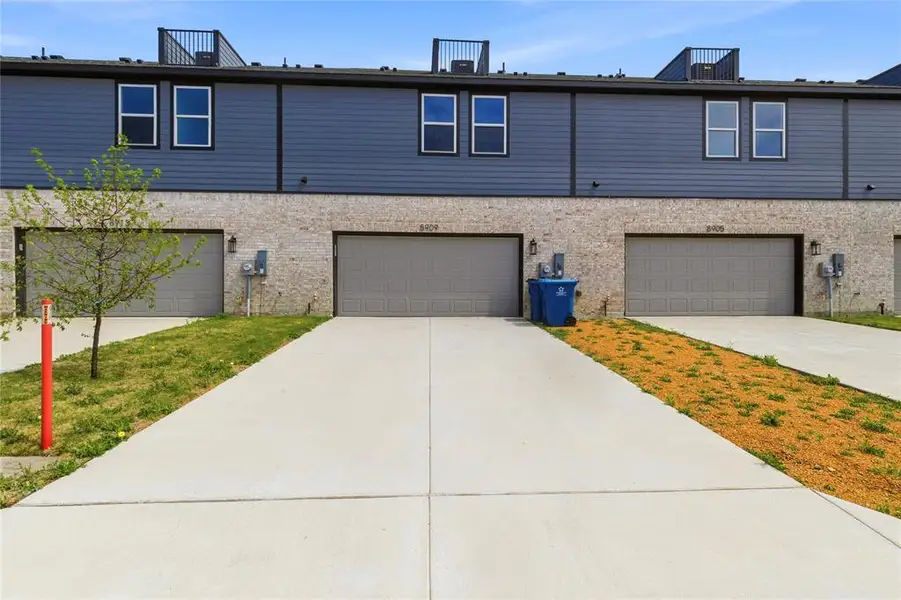 View of front of property with concrete driveway and a garage