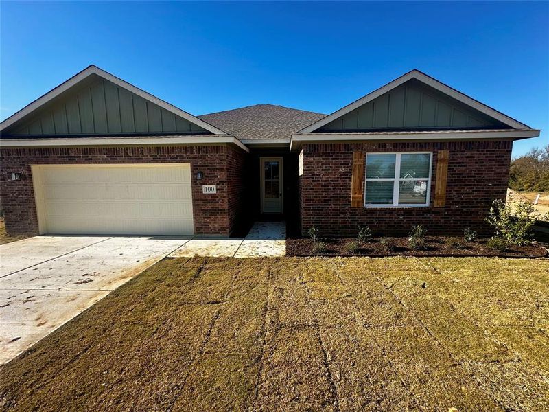 Single story home with a garage and a front lawn