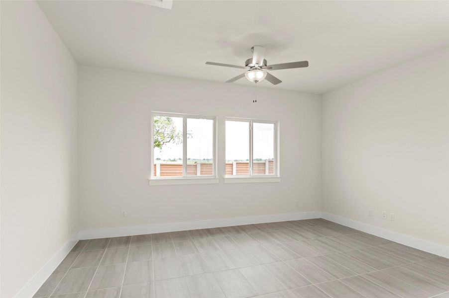 Unfurnished room with a ceiling fan and baseboards