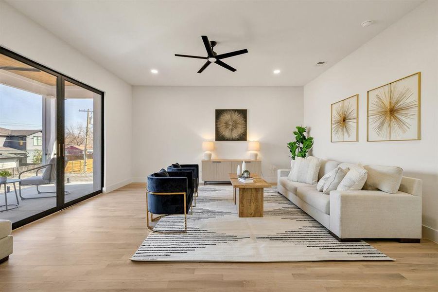 Living room with ceiling fan and light hardwood / wood-style flooring