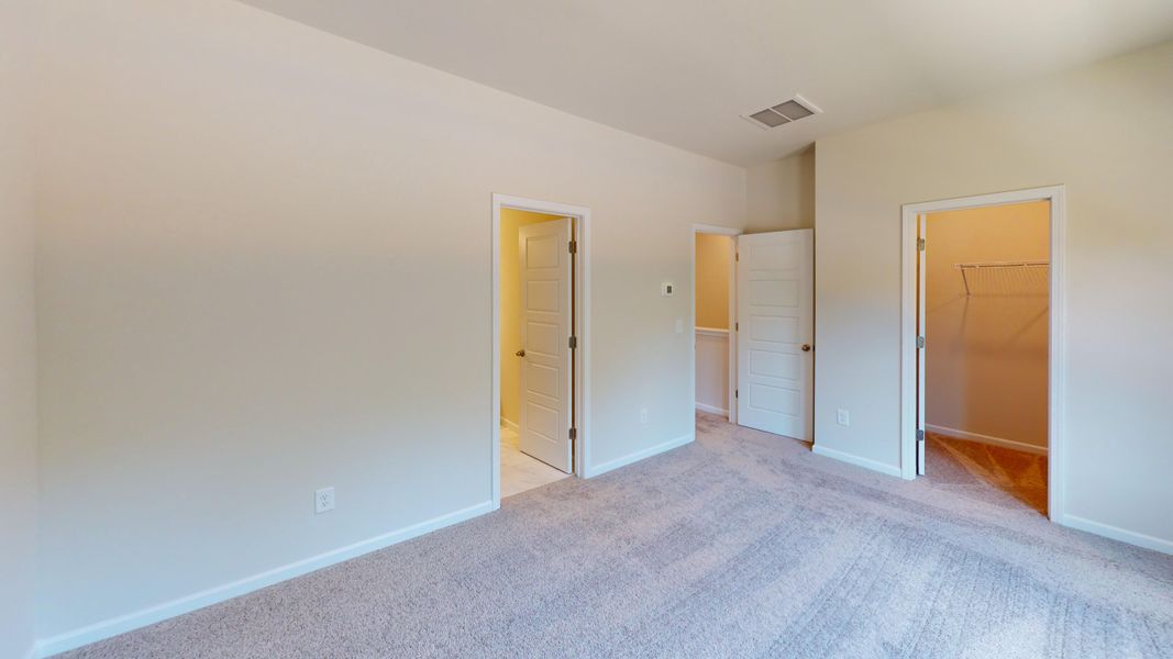 Spacious Owner's Suite bedroom with en suite bathroom and walk-in closet.