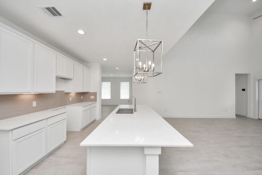 This kitchen is truly a chef's dream! This haven Boasts high ceilings, recessed & pendant lighting, stained wood cabinets, granite countertops, stainless steel appliances, a modern tile backsplash. All of this overlooks your expansive family room, creating a perfect space for culinary delights and family gatherings. Sample photo of completed home with similar floor plan. Actual colors and selections may vary. This kitchen is truly a chef's dream! This haven Boasts high ceilings, recessed & pendant lighting, stained wood cabinets, granite countertops, stainless steel appliances, a modern tile backsplash. All of this overlooks your expansive family room, creating a perfect space for culinary delights and family gatherings. Sample photo of completed home with similar floor plan. Actual colors and selections may vary.