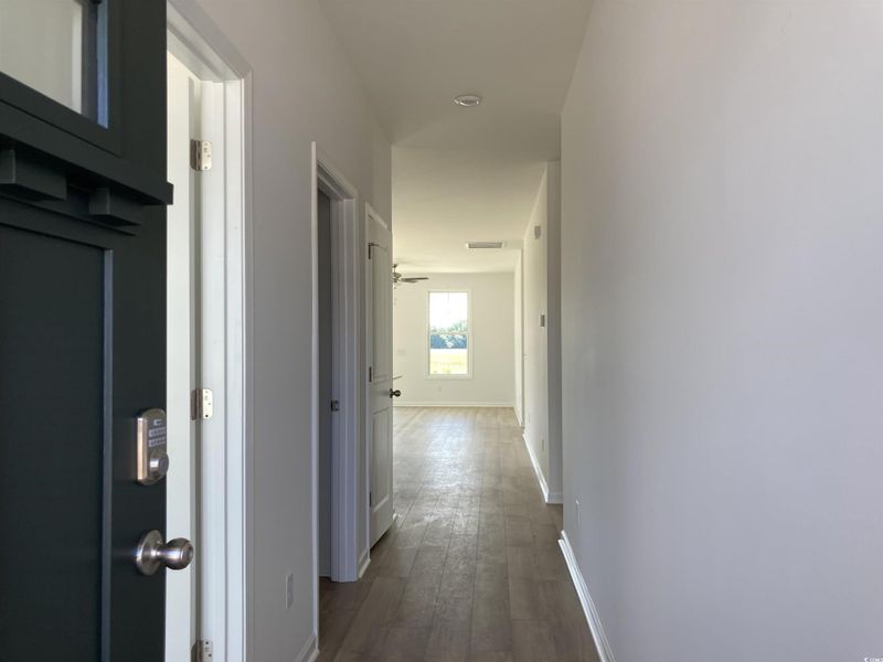 Hall with baseboards and dark wood-style floors