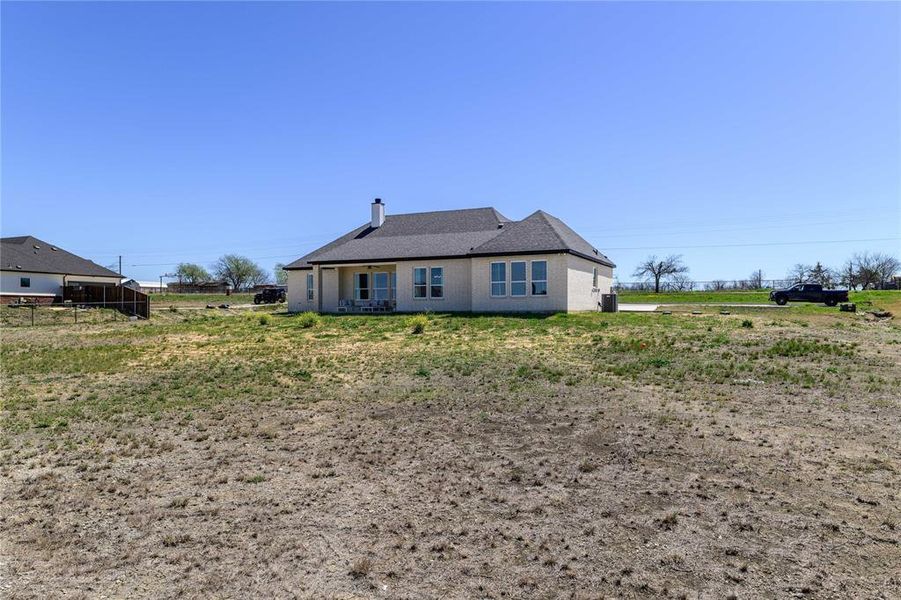Back of property featuring a chimney and brick siding Back of property featuring a chimney and brick siding