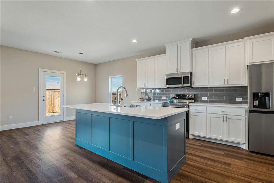Kitchen featuring white cabinetry, an island with sink, dark hardwood / wood-style floors, and appliances with stainless steel finishes Kitchen featuring white cabinetry, an island with sink, dark hardwood / wood-style floors, and appliances with stainless steel finishes