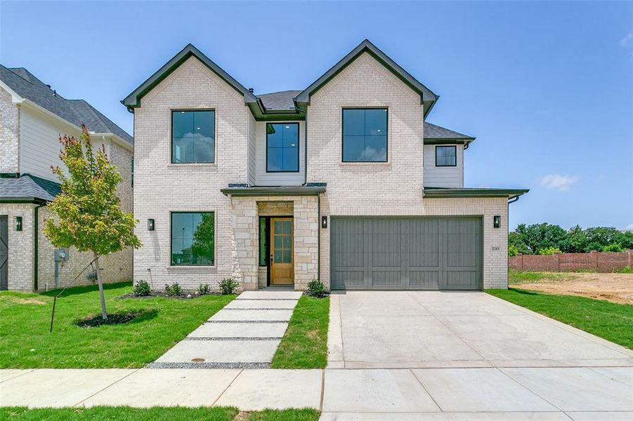 Contemporary house with an attached garage, concrete driveway, and brick siding Contemporary house with an attached garage, concrete driveway, and brick siding