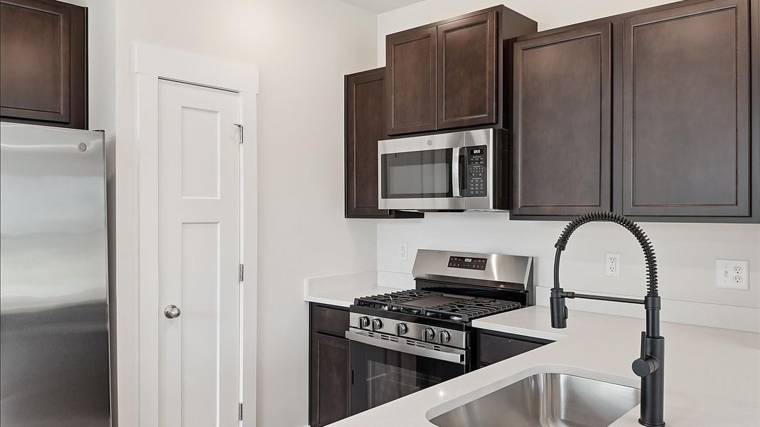 Elegant kitchen featuring quartz countertops and current styling throughout located at the Clarke Townes community