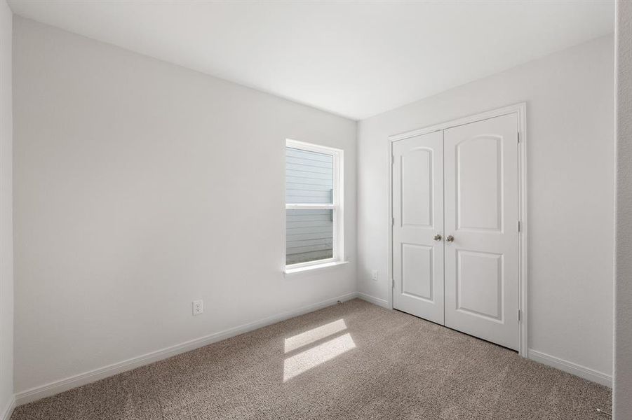 Unfurnished bedroom with carpet flooring and a closet Unfurnished bedroom with carpet flooring and a closet