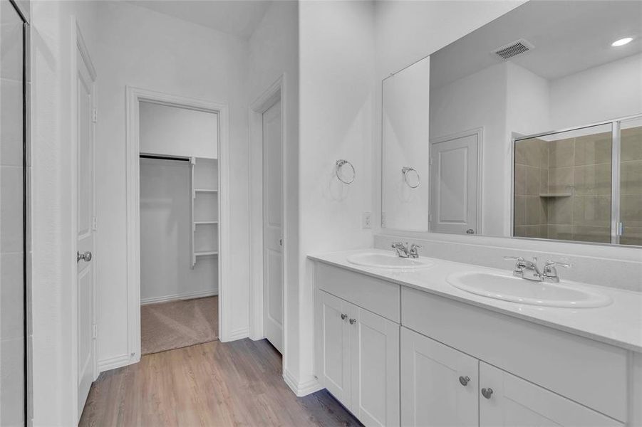 Bathroom with an enclosed shower, vanity, and hardwood / wood-style flooring