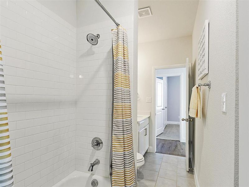 Full bathroom featuring toilet, tile patterned floors, vanity, and shower / tub combo