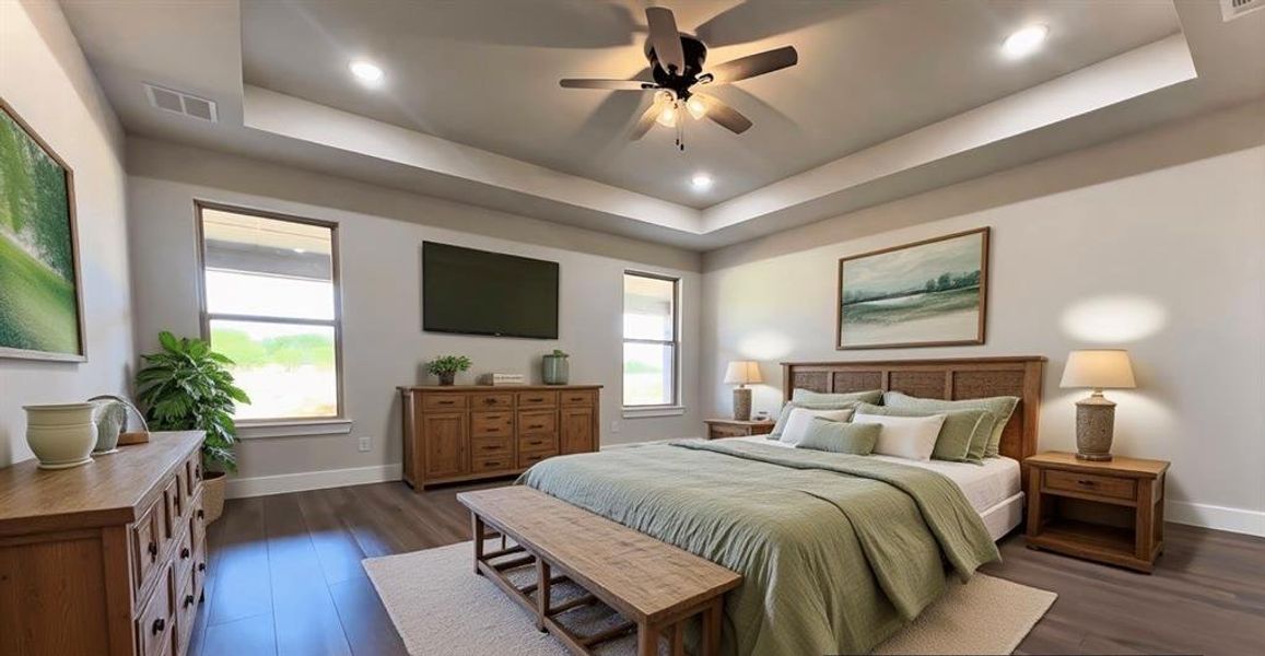 Bedroom featuring a raised ceiling, dark  flooring, and ceiling fan