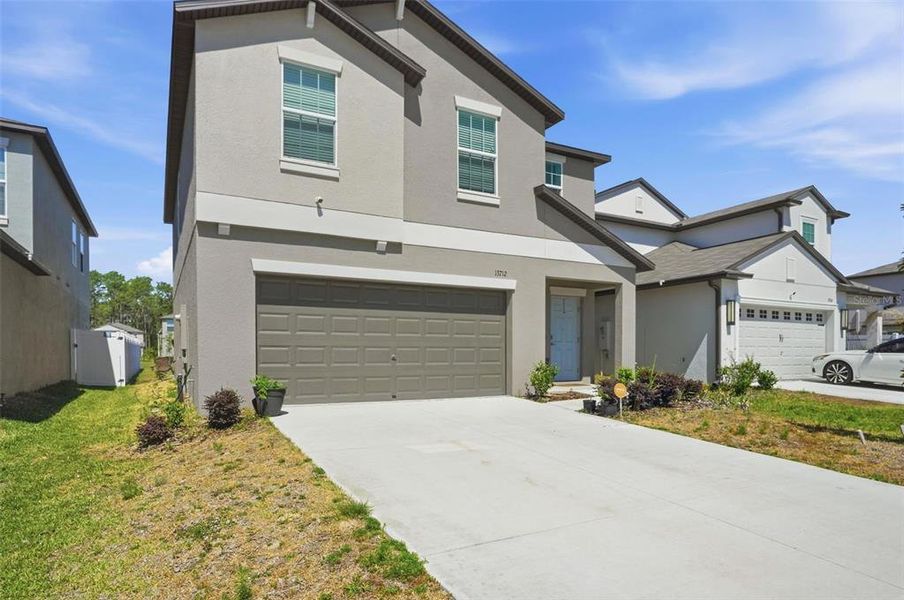 Front exterior of a new home in The Isle of Avalon, Spring Hill, FL, highlighting curb appeal (Image 24).