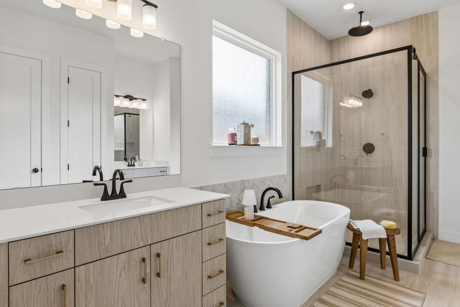 Modern finishes define this bright space featuring a freestanding tub and walk-in shower.