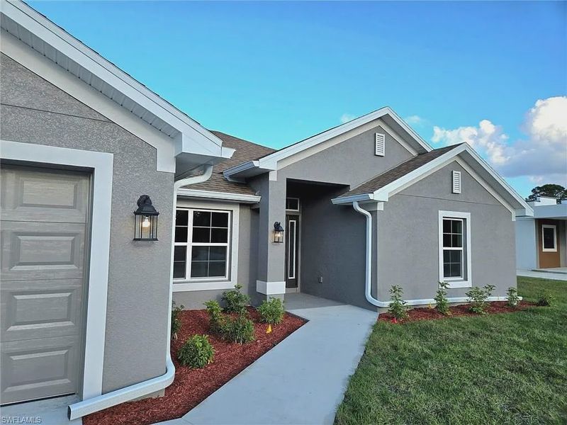 Front exterior of a new home in Greenbriar, Lehigh Acres, FL, highlighting curb appeal (Image 2).