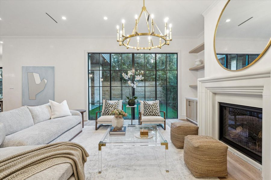 The living room with its custom cast stone mantel, the focal point of the room, The chandelier vies for prominence, as well.  A huge room with great views of the back yard.