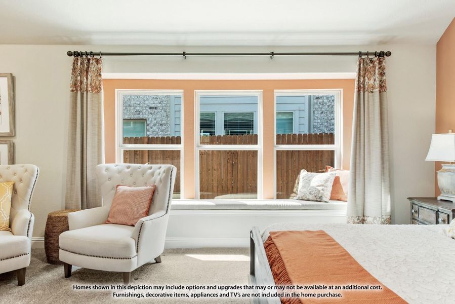 Bedroom with window seat, three windows, accent chair, and peach-colored walls Bedroom with window seat, three windows, accent chair, and peach-colored walls