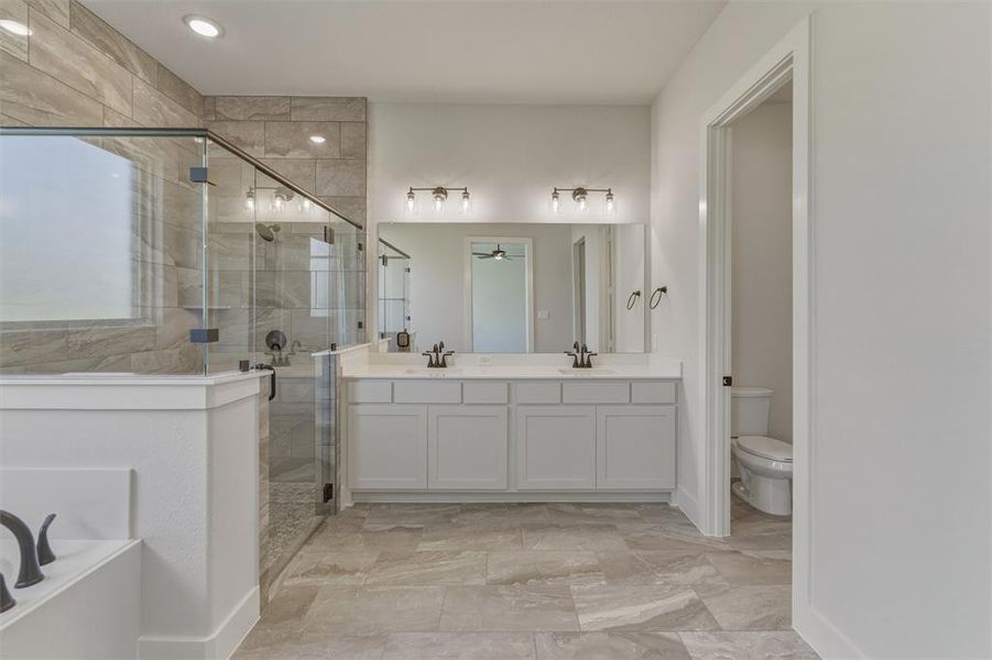 Full bathroom featuring a double vanity with white cabinetry, light countertops, and dark fixtures Full bathroom featuring a double vanity with white cabinetry, light countertops, and dark fixtures