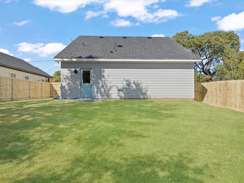 Back of house with roof with shingles and a fenced backyard Back of house with roof with shingles and a fenced backyard