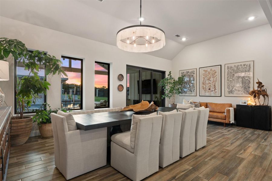 This naturally illuminated dining space boasts high ceilings, recessed lighting, and a view of the sunset through large windows. This naturally illuminated dining space boasts high ceilings, recessed lighting, and a view of the sunset through large windows.