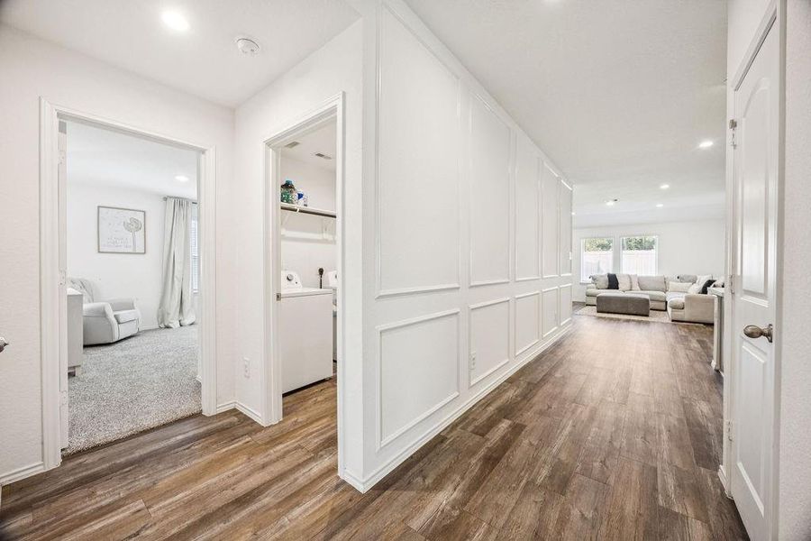 Bright and welcoming hallway featuring elegant wood flooring and stylish wall paneling, seamlessly connecting living spaces. Bright and welcoming hallway featuring elegant wood flooring and stylish wall paneling, seamlessly connecting living spaces.