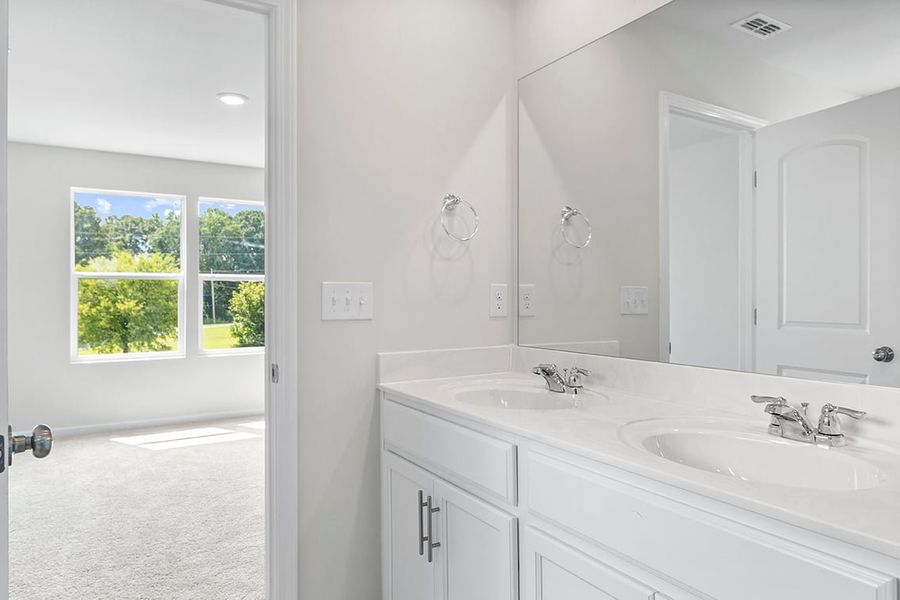 A bathroom with white cabinets.