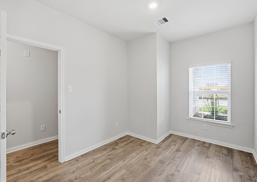 Secondary bedroom featuring a window and wood-look flooring.