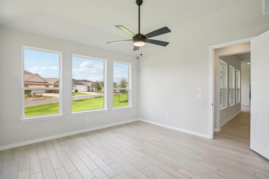 Empty room featuring light wood finished floors and a ceiling fan