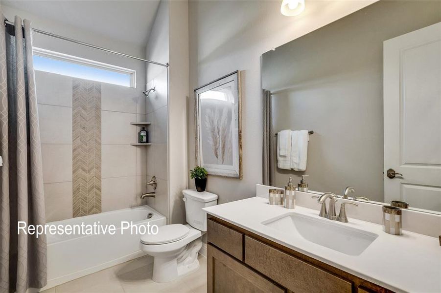 Full bathroom featuring toilet, shower / bath combo, vanity, and tile patterned floors