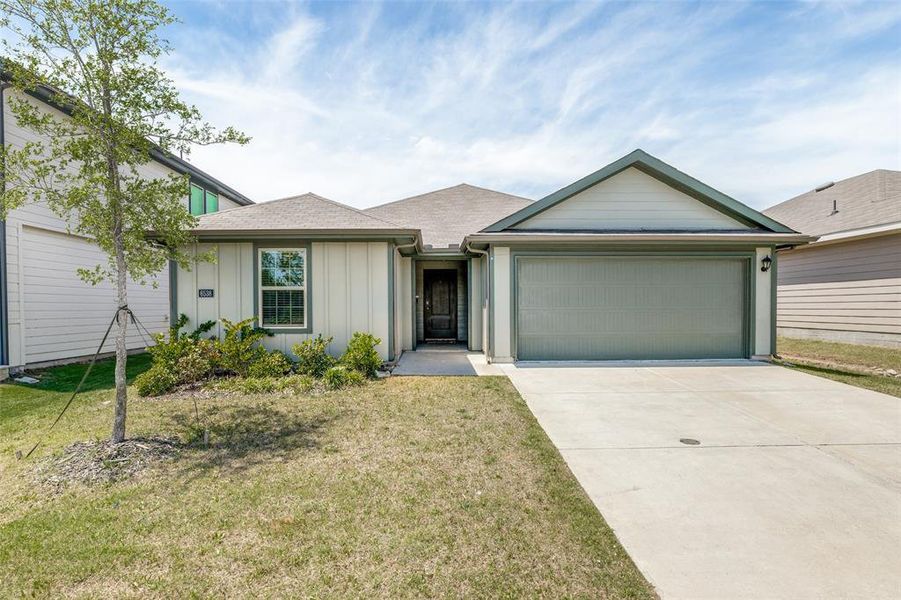 Single-story residence featuring light-colored siding, a dark green accent gable, and a two-car garage Single-story residence featuring light-colored siding, a dark green accent gable, and a two-car garage