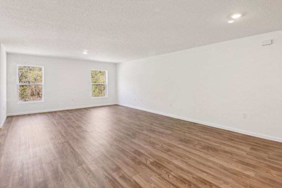 A room with a wood floor and paintings on the wall.
